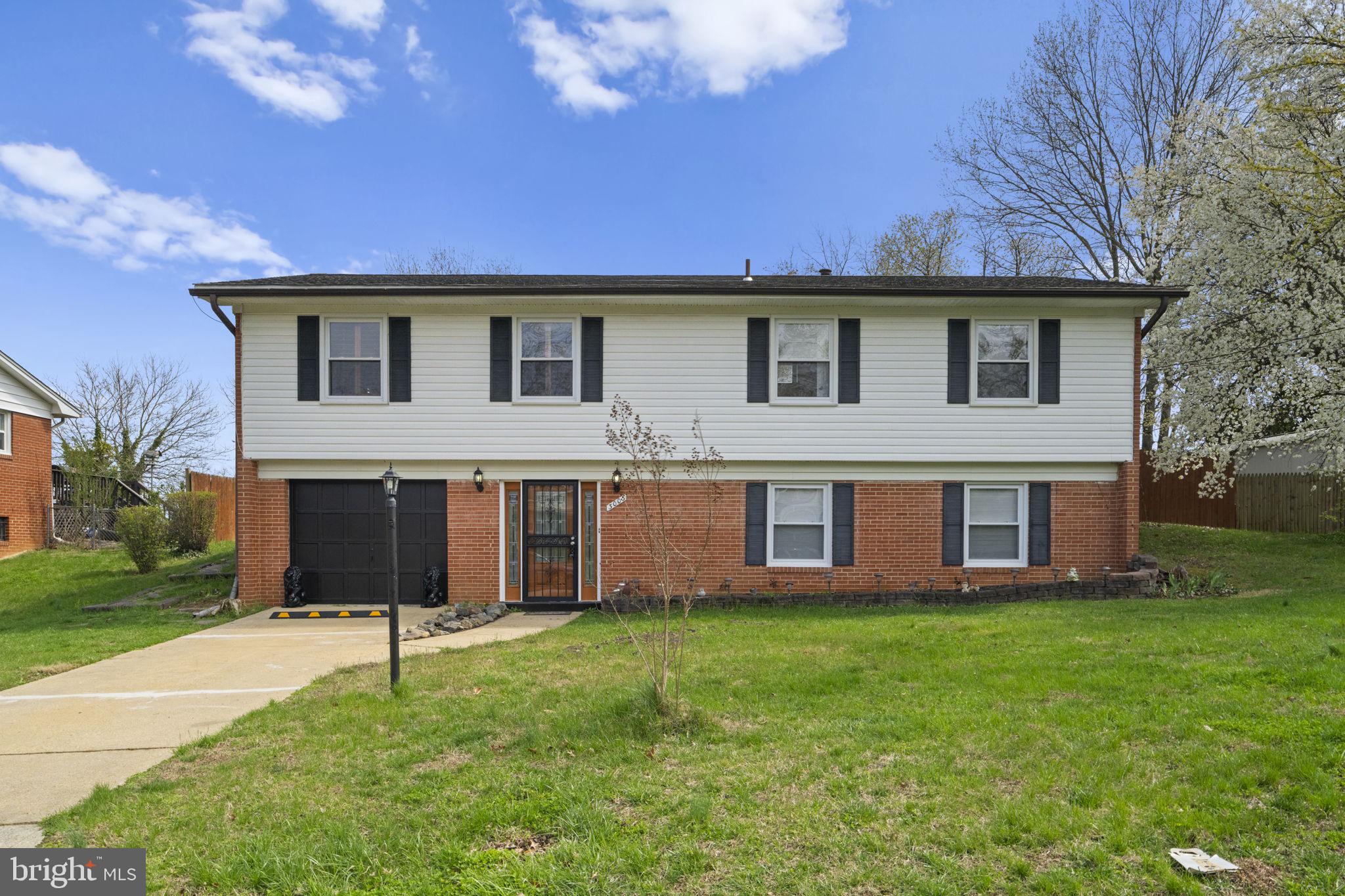 3003 Raymond Court Fort Washington, MD 20744 - Photo 1 of 30 a front view of a house with a yard and garage