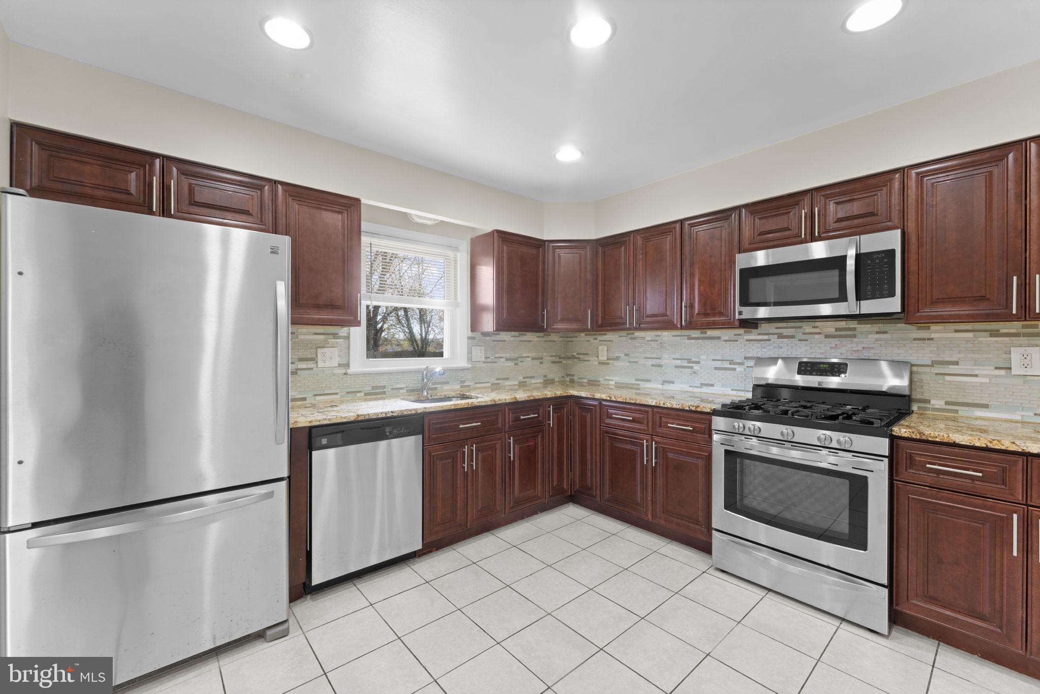 3003 Raymond Court Fort Washington, MD 20744 - Photo 17 of 30 a kitchen with stainless steel appliances granite countertop a refrigerator stove a sink dishwasher and microwave