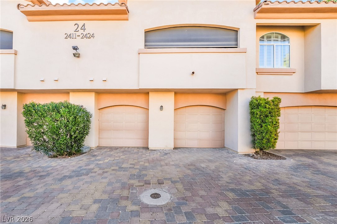 2050 West Warm Springs Road, Unit 2411 Henderson, NV 89014 - Photo 3 of 37 A well-maintained facade features multiple garage doors and attractive landscaping, enhancing curb appeal.
