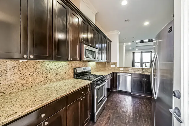 a kitchen with granite countertop stainless steel appliances and wooden cabinets