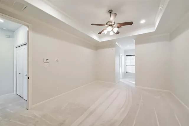 an empty room with windows and fan