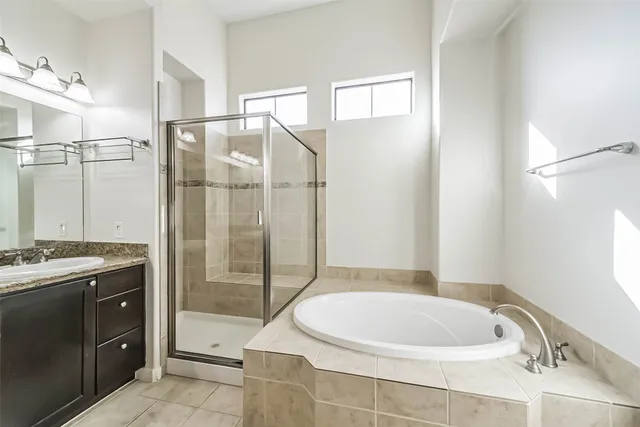 a bathroom with a tub a sink and glass door