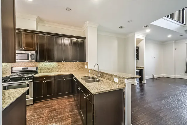 a kitchen with granite countertop a sink and stainless steel appliances