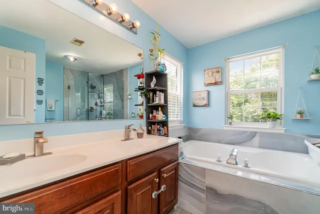 a bathroom with a sink a toilet a mirror and shower