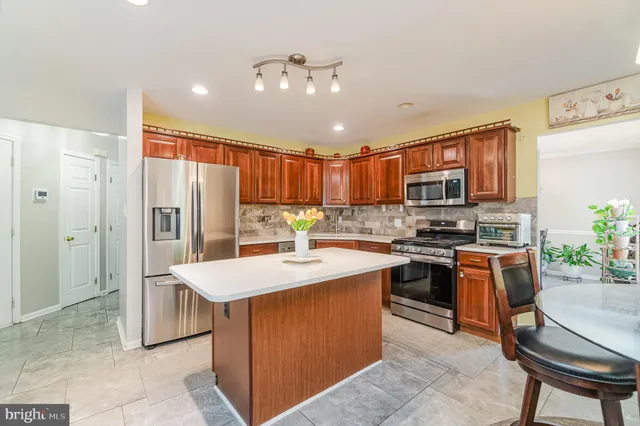 a kitchen with stainless steel appliances granite countertop a sink a refrigerator and cabinets