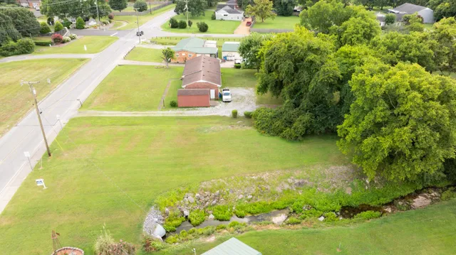 an aerial view of a house with a yard and trees