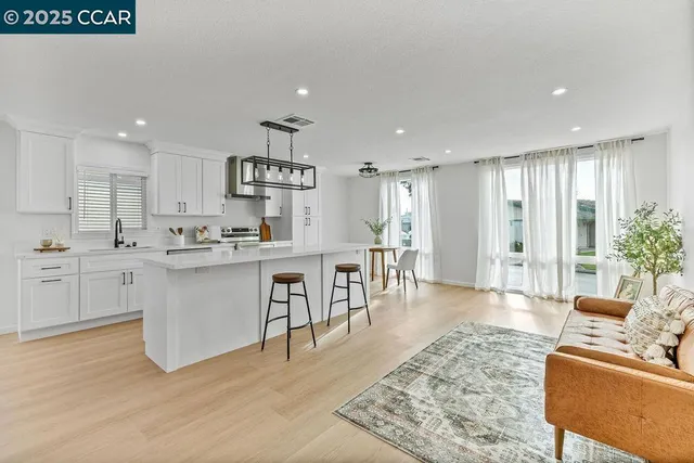 a open kitchen with white cabinets and stainless steel appliances