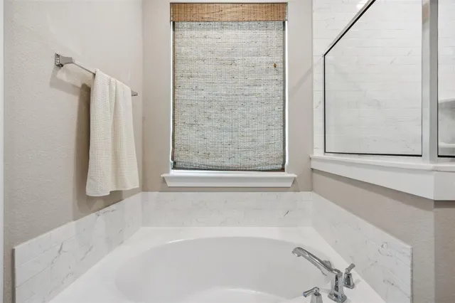 a bathroom with bathtub and shower