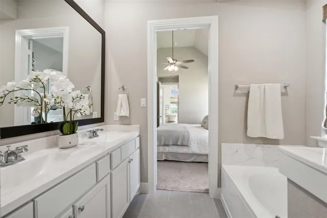 a bathroom with a tub sink and mirror
