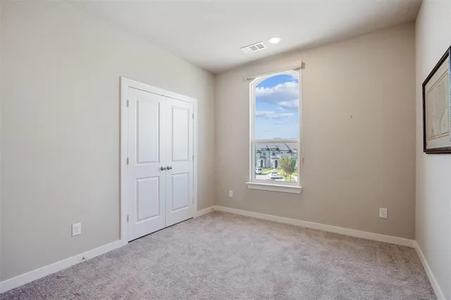 an empty room with windows and closet