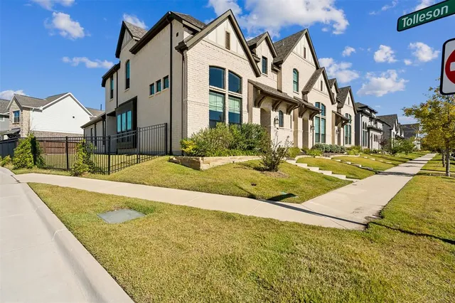 a view of a white building with a yard