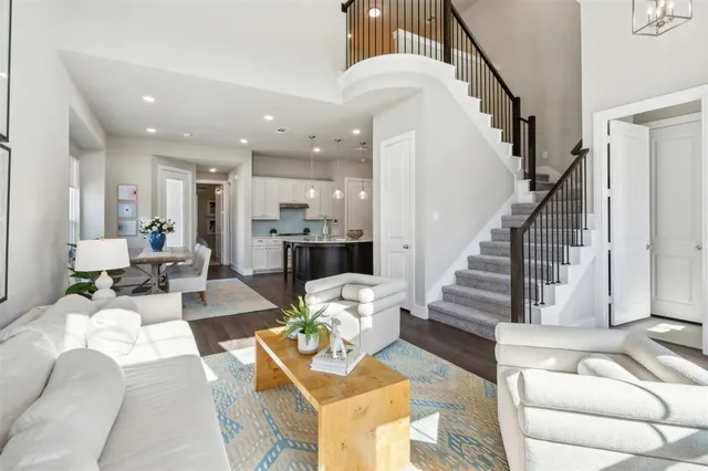 a living room with furniture kitchen view and a chandelier