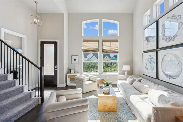 a living room with furniture large window and wooden floor