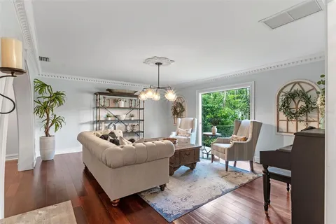 a living room with furniture a table and a chandelier