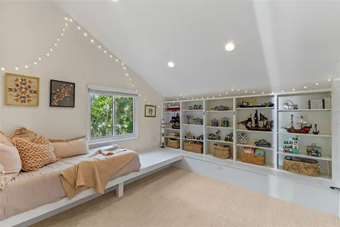 a view of a patio with table and chairs under an umbrella with a barbeque