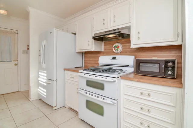 a stove top oven sitting inside of a kitchen