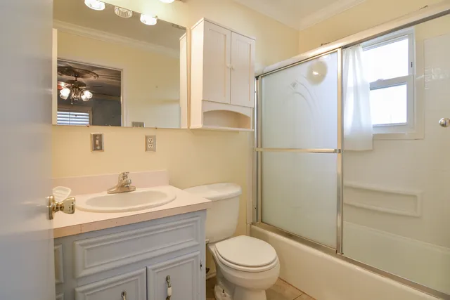 en empty room with a fireplace and chandelier fan