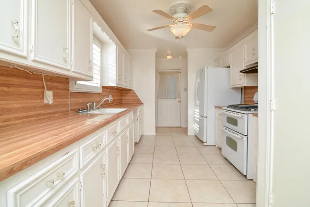 a kitchen with granite countertop white cabinets and white appliances