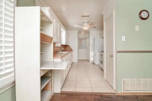 a kitchen with white cabinets and white appliances