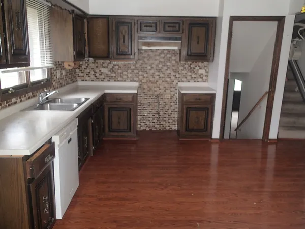 a kitchen with a sink cabinets and wooden floor