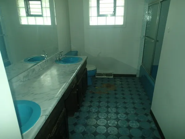 a bathroom with a granite countertop sink a toilet and a mirror