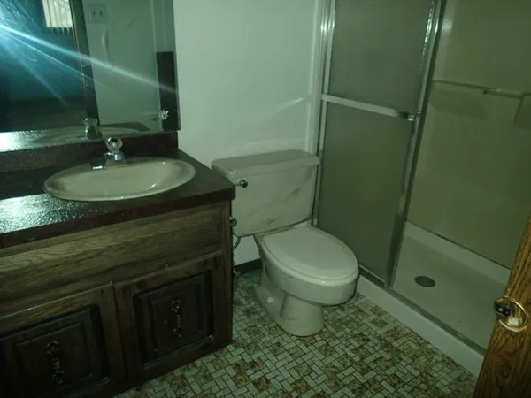 a bathroom with a granite countertop sink toilet and shower