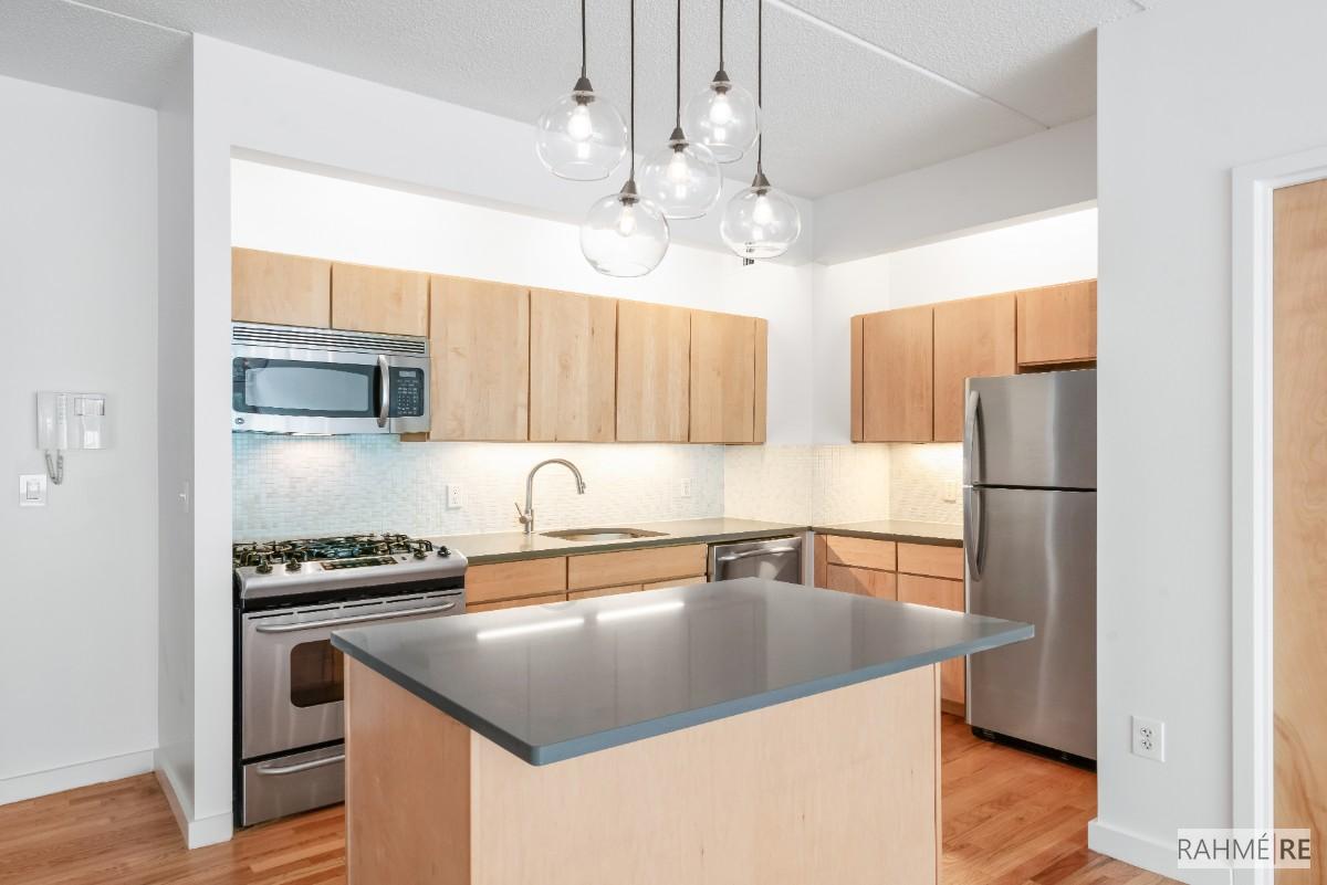 a kitchen with stainless steel appliances granite countertop a sink a stove and a refrigerator