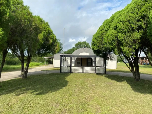 a white house with a large tree with yard