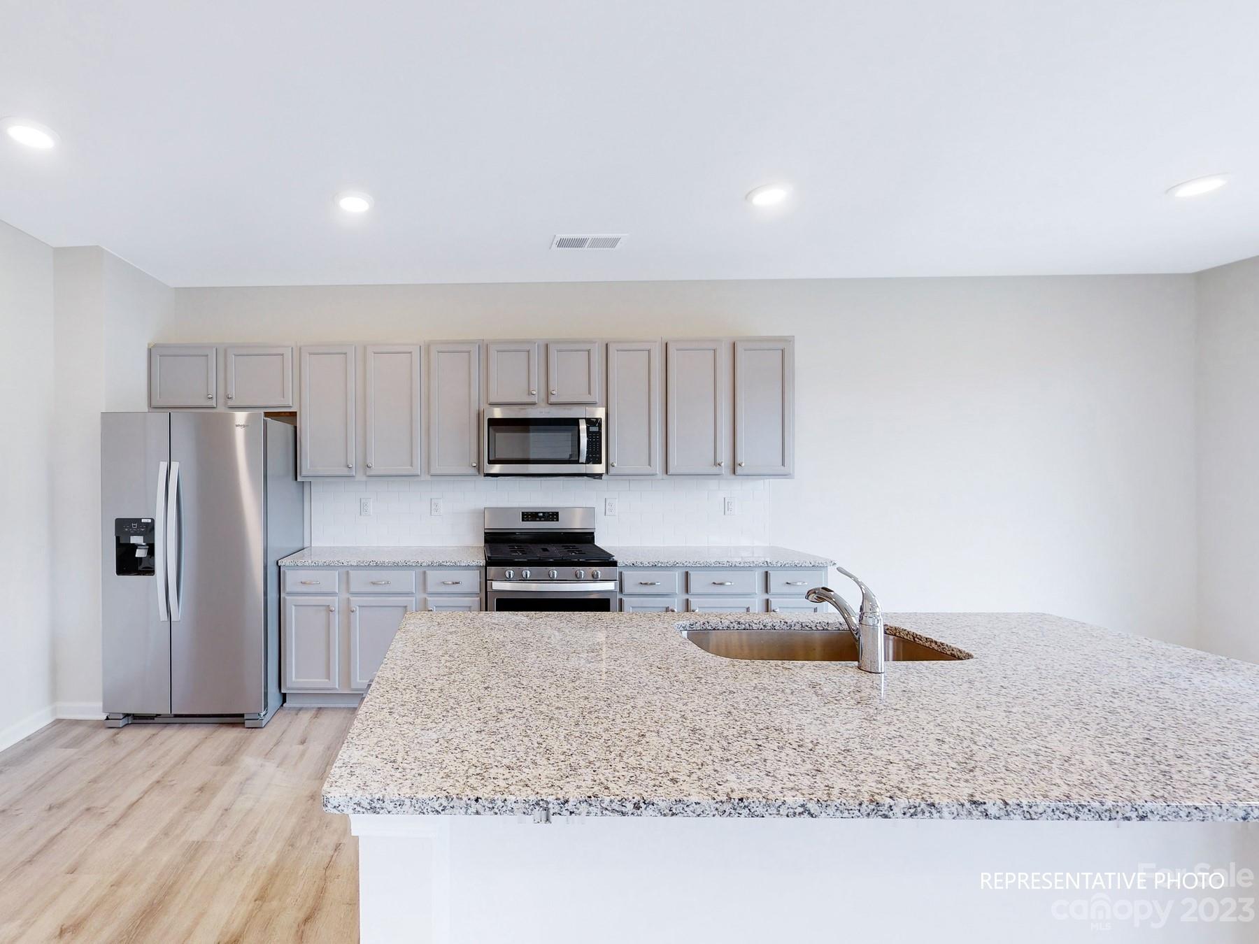 5028 Raspberry Knoll Drive, Unit 1 Charlotte, NC 28208 - Photo 2 of 16 a kitchen with granite countertop a refrigerator sink and stove
