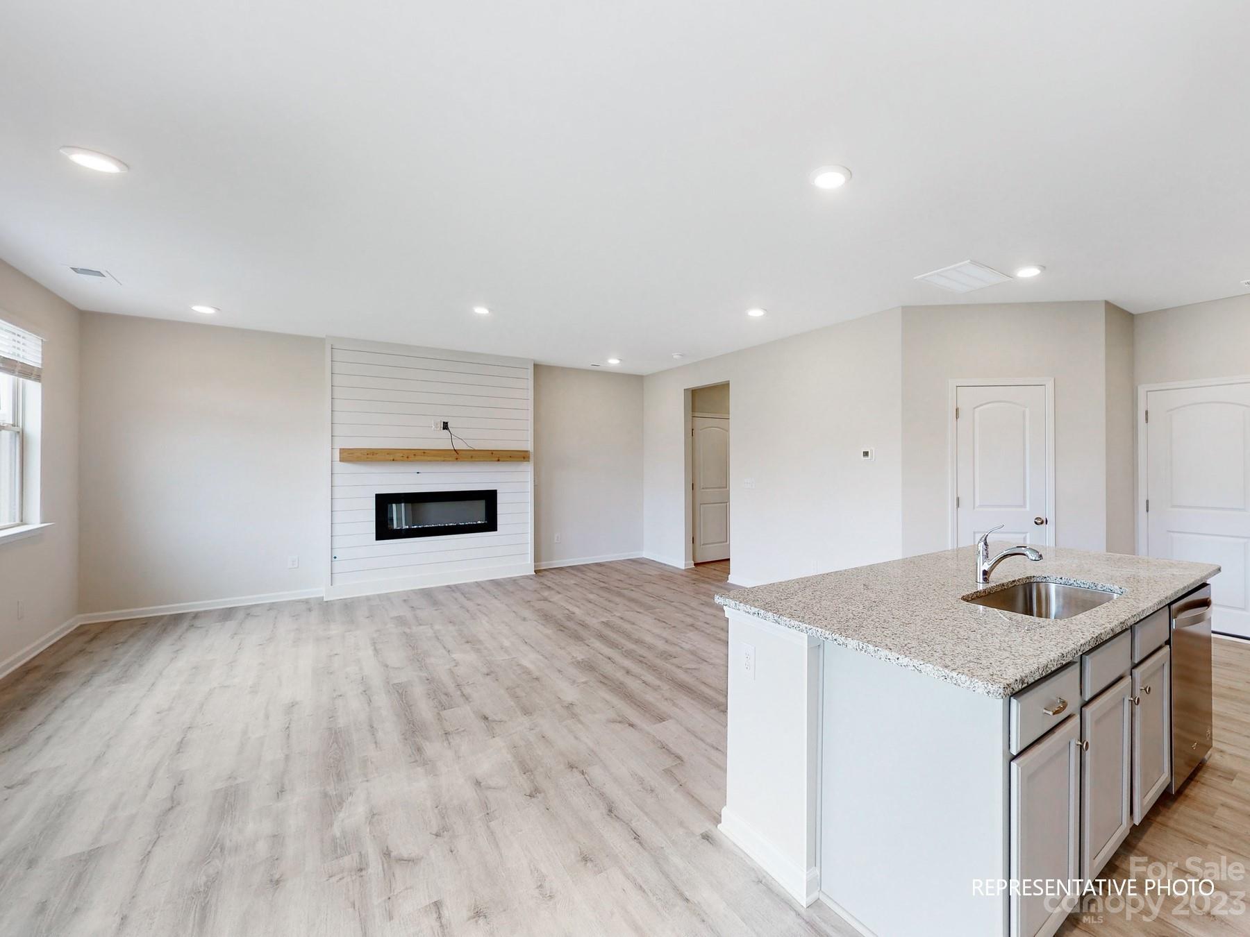 5028 Raspberry Knoll Drive, Unit 1 Charlotte, NC 28208 - Photo 3 of 16 a kitchen with sink and microwave with wooden floor