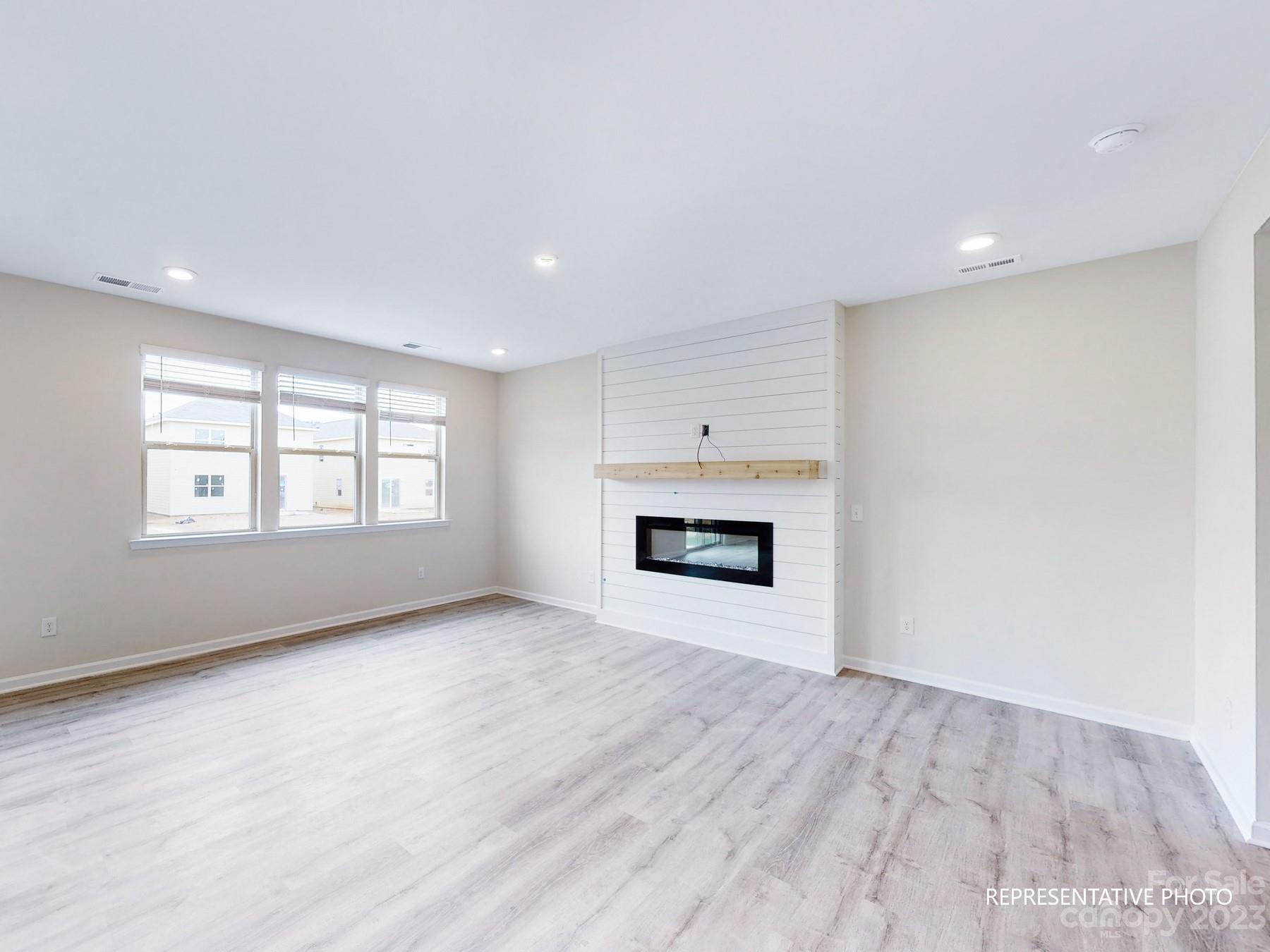 5028 Raspberry Knoll Drive, Unit 1 Charlotte, NC 28208 - Photo 4 of 16 wooden floor in an empty room with a window