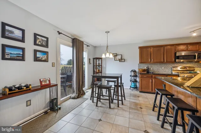a kitchen with granite countertop a stove a sink and a refrigerator