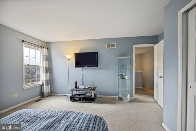 a living room with furniture a flat screen tv and a window