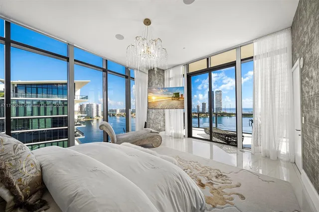 a bedroom with a large bed and a chandelier