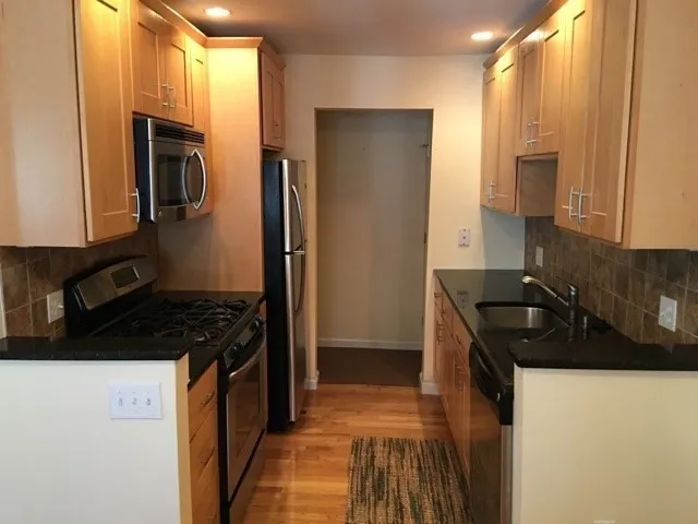 a kitchen with stainless steel appliances granite countertop a sink stove and refrigerator