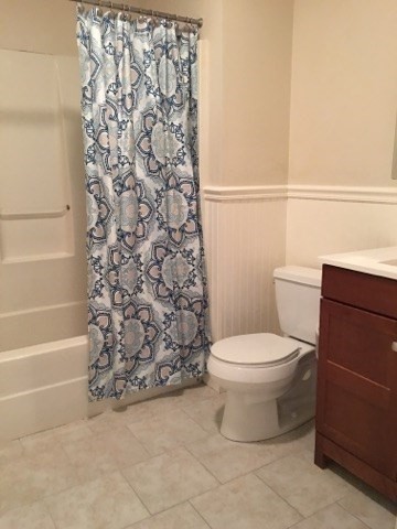 66 St James Street, Unit 209 Boston, MA 02119 - Photo 19 of 20 a bathroom with a toilet and a shower curtain