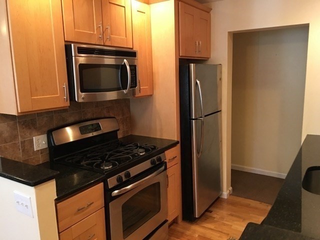 66 St James Street, Unit 209 Boston, MA 02119 - Photo 2 of 20 a kitchen with a stove microwave and refrigerator