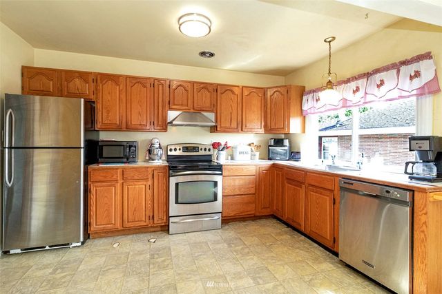 a kitchen with stainless steel appliances granite countertop a refrigerator sink and cabinets