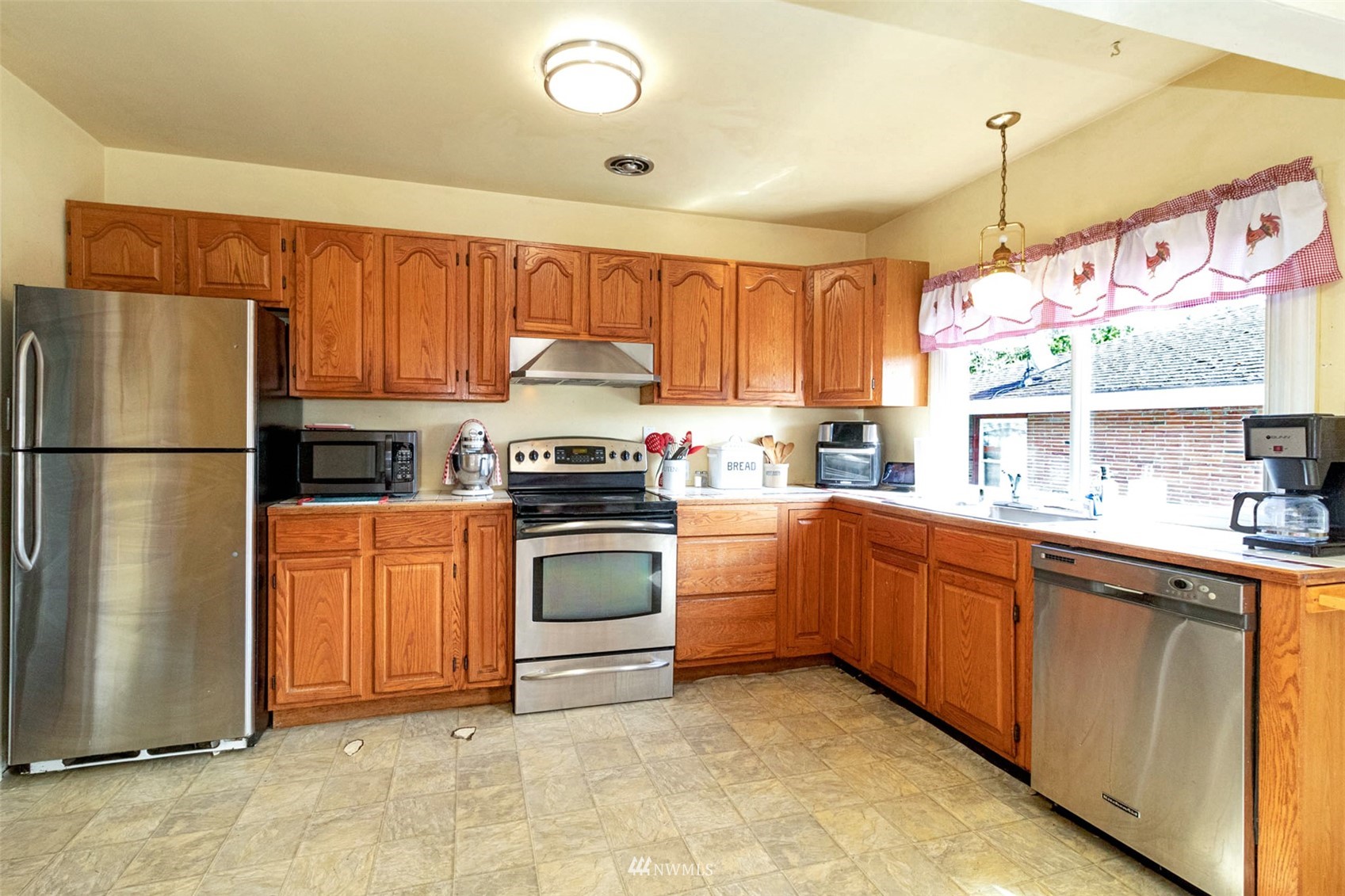 627 Madison Street Everett, WA 98203 - Photo 11 of 23 a kitchen with stainless steel appliances granite countertop a refrigerator sink and cabinets