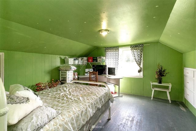 a bedroom with a bed table and chair