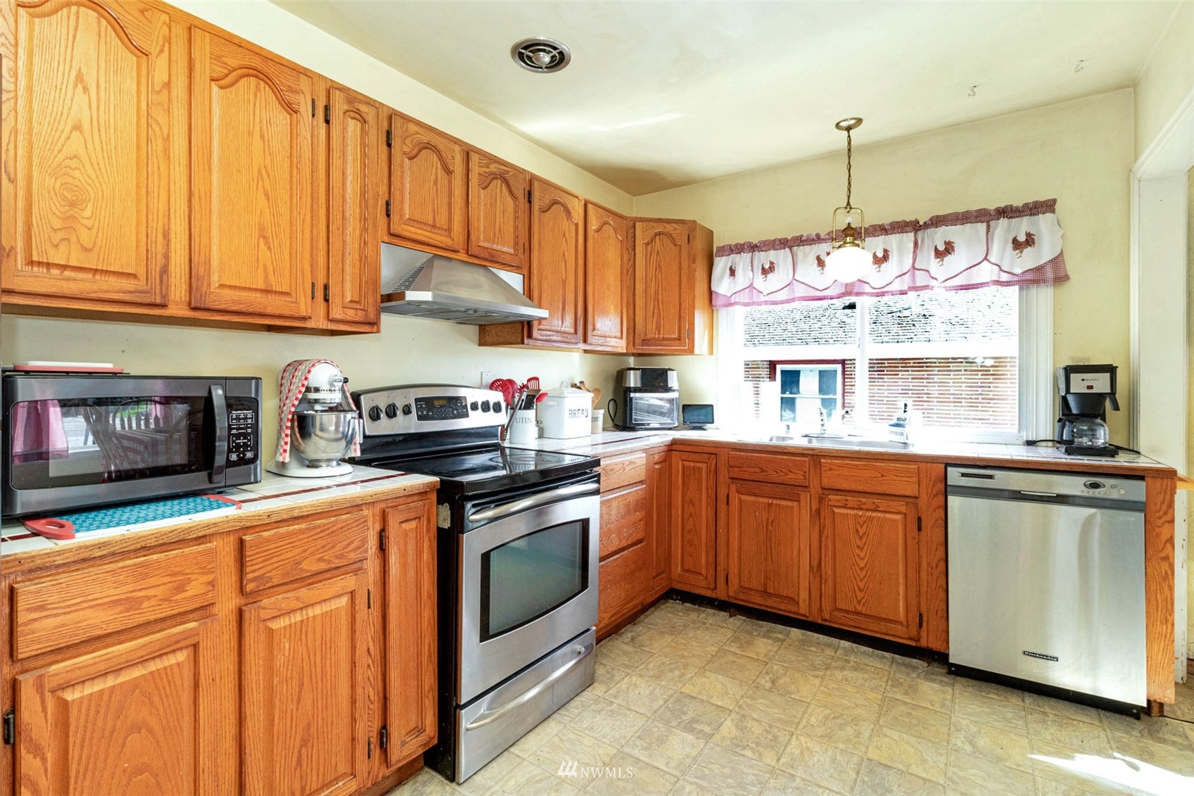 627 Madison Street Everett, WA 98203 - Photo 9 of 23 a kitchen with stainless steel appliances granite countertop a stove a sink dishwasher and cabinets with wooden floor