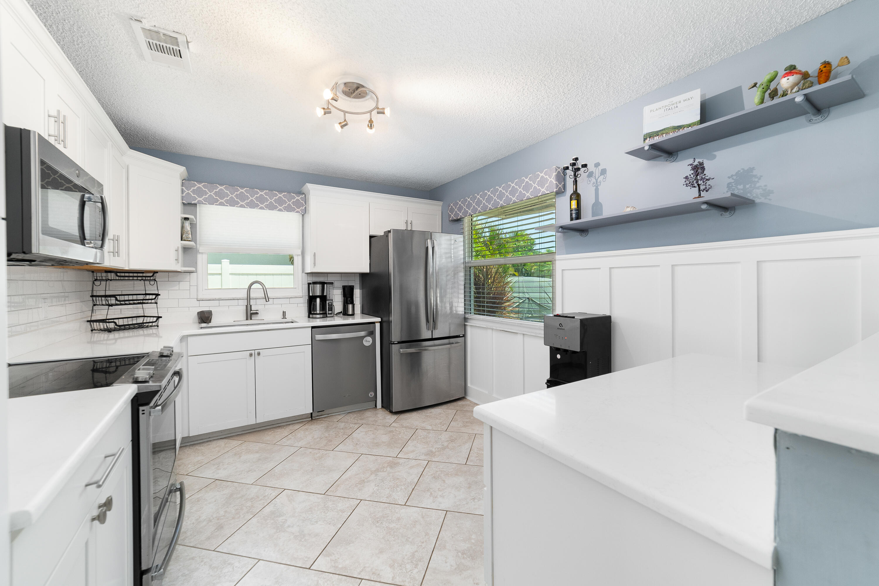 142 Timberline Drive Jupiter, FL 33458 - Photo 13 of 35 a kitchen with a sink a refrigerator and cabinets