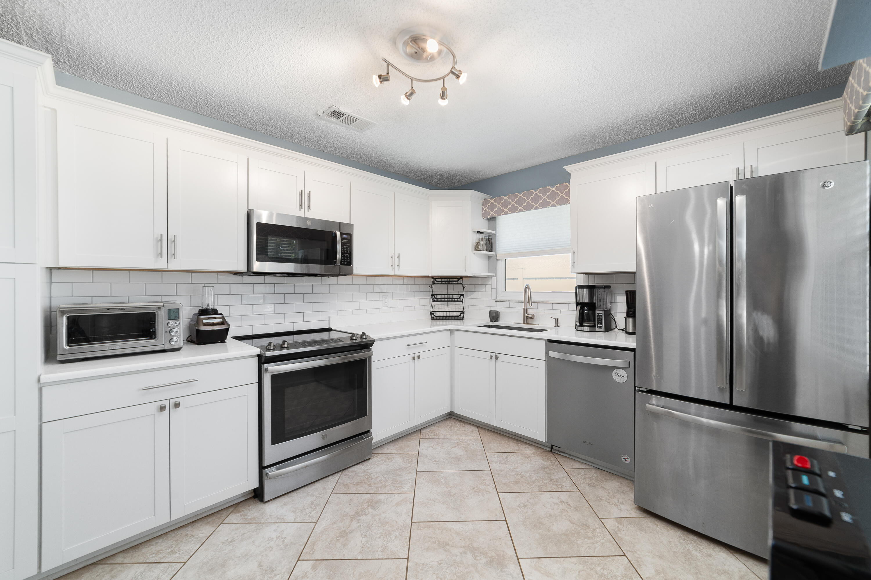 142 Timberline Drive Jupiter, FL 33458 - Photo 15 of 35 a kitchen with cabinets stainless steel appliances and a counter top space