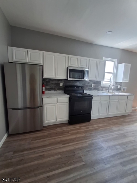 904 South 18th Street Newark, NJ 07108 - Photo 1 of 11 a kitchen with a refrigerator a microwave a sink and cabinets