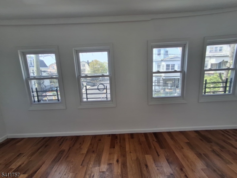 904 South 18th Street Newark, NJ 07108 - Photo 8 of 11 a view of an empty room with wooden floor and a window