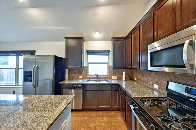 a bathroom with a granite countertop toilet and a sink