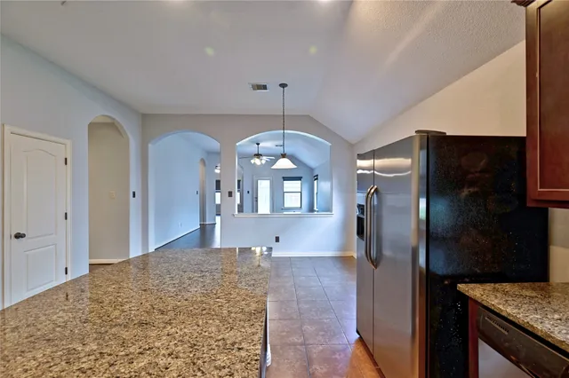 a view of an empty room with wooden floor and a bathroom