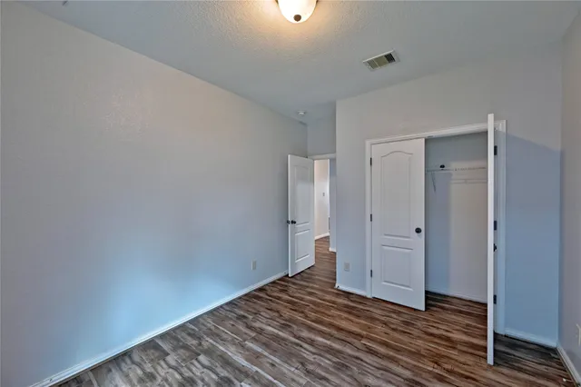a view of a room with wooden floor a ceiling fan and closet