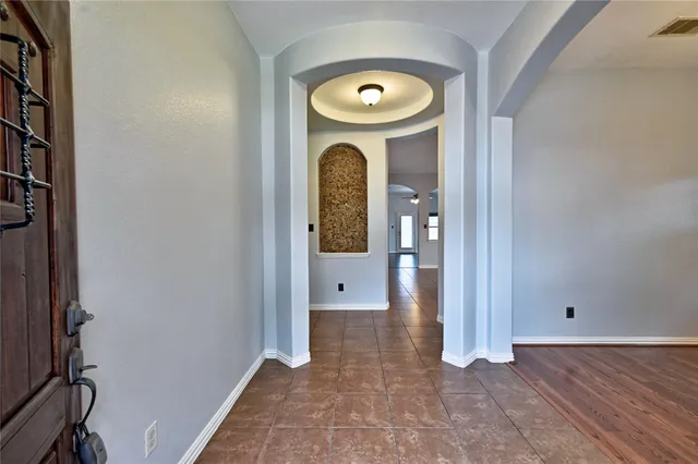 a view of a hallway with wooden floor and a living room