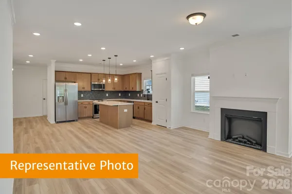 a view of kitchen with kitchen island granite countertop a stove top oven a sink and a refrigerator